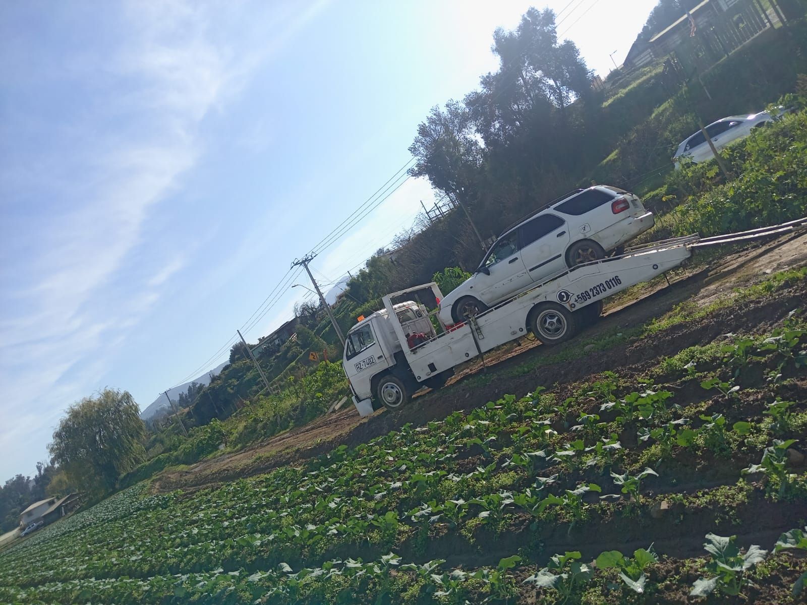 Una grúa está remolcando un automóvil en un campo.