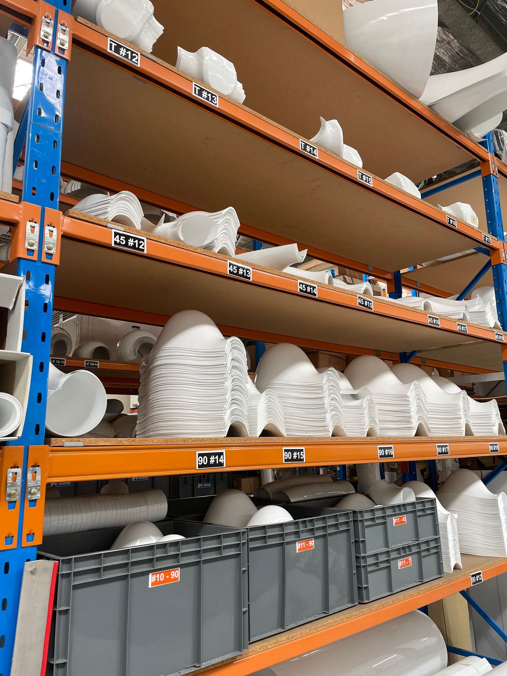 Shelves of our white PVC items in our warehouse, organised by shape and size.