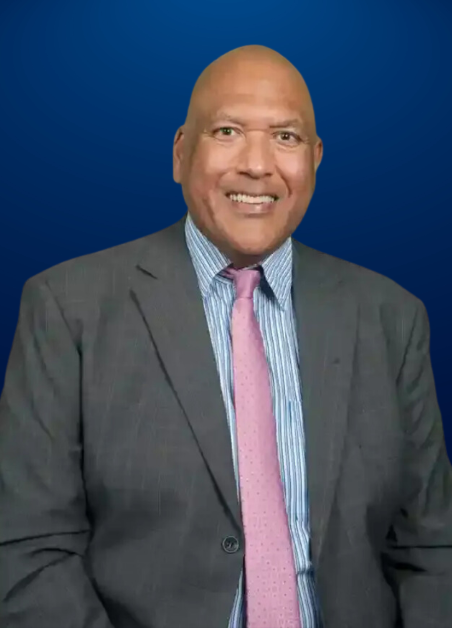 A man in a suit and tie is smiling for the camera