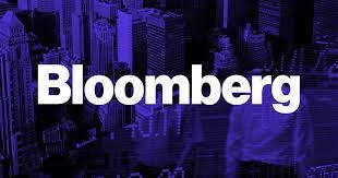 The logo for bloomberg is purple and white with a city in the background.