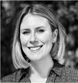 A woman is smiling in a black and white photo.