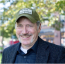 A man in a suit and hat is smiling for the camera.