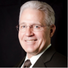 A man in a suit and tie is smiling for the camera.