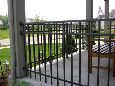 A white fence surrounds a lush green field.