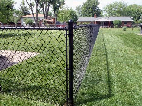 A close up of a chain link fence with a green background.