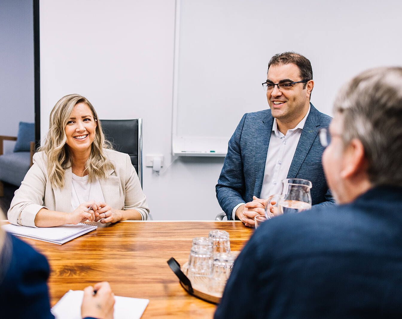 A Group Of People Are Sitting Around A Table Having A Meeting — The Garis Group In Hamilton, NSW
