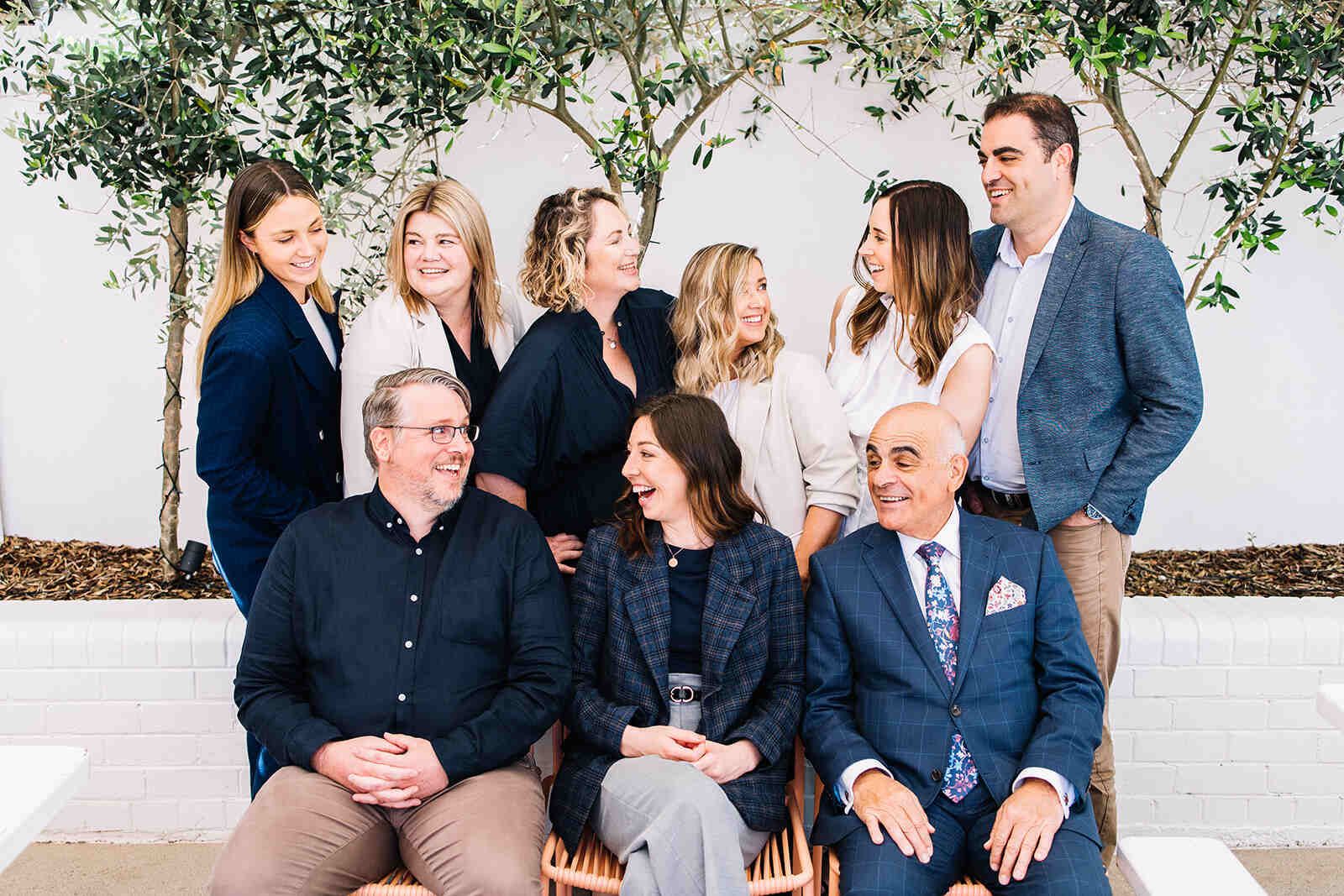 A Group Of People Are Posing For A Picture While Sitting On A Bench — The Garis Group In Hamilton, NSW