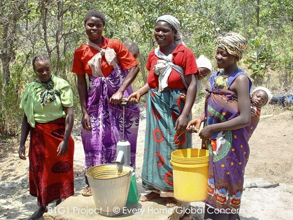A Group Of Women Are Standing Next To Each Other Holding Buckets Of Water — The Garis Group  In Hamilton, NSW 