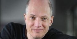 A Bald Man In A Black Shirt Is Smiling For The Camera — The Garis Group  In Hamilton, NSW 
