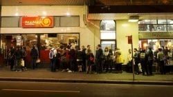 A Large Group Of People Are Standing Outside Of A Building — The Garis Group  In Hamilton, NSW