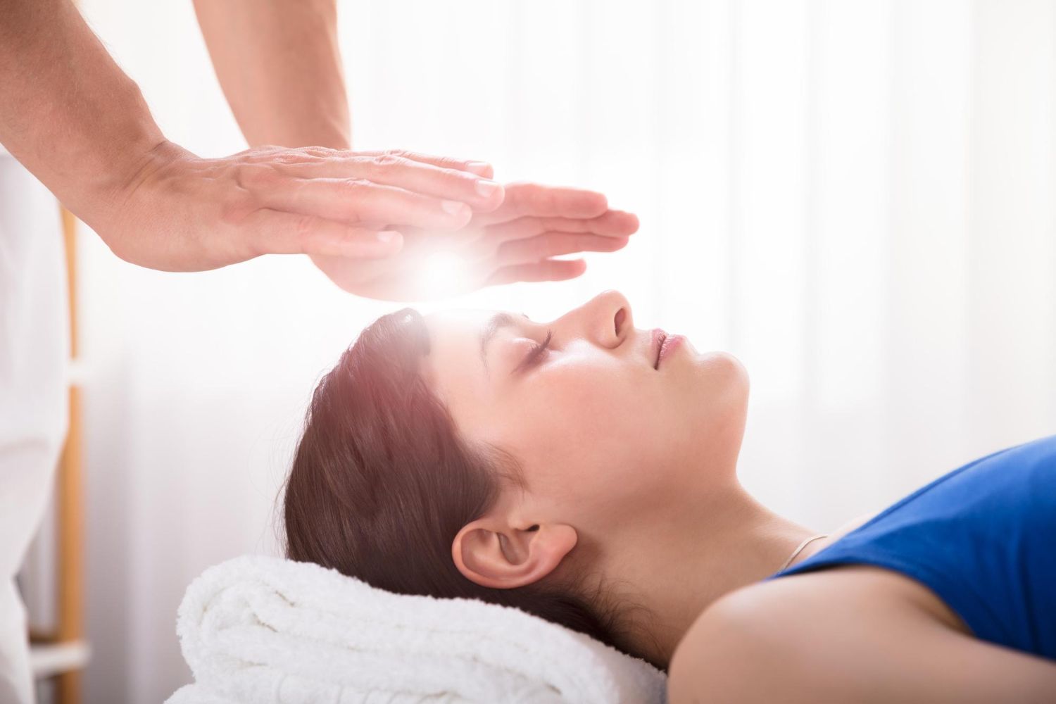 A woman is getting a healing session at a spa.