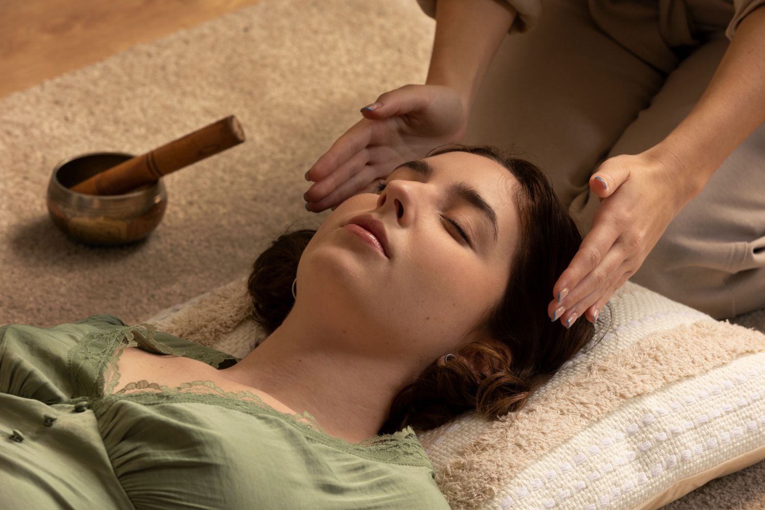 A woman is laying on a pillow getting a massage from a person.