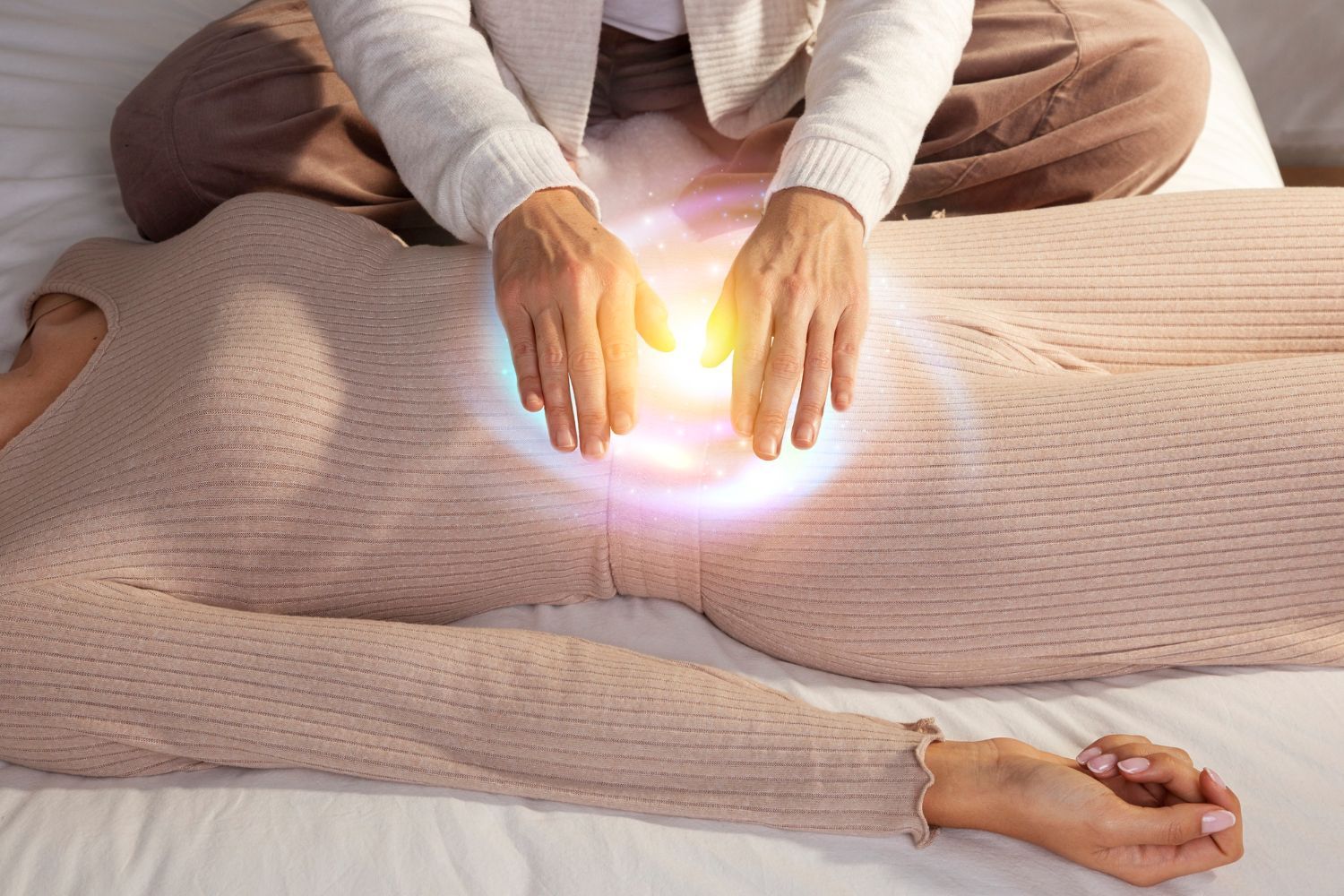 A woman is laying on a bed getting a healing session.