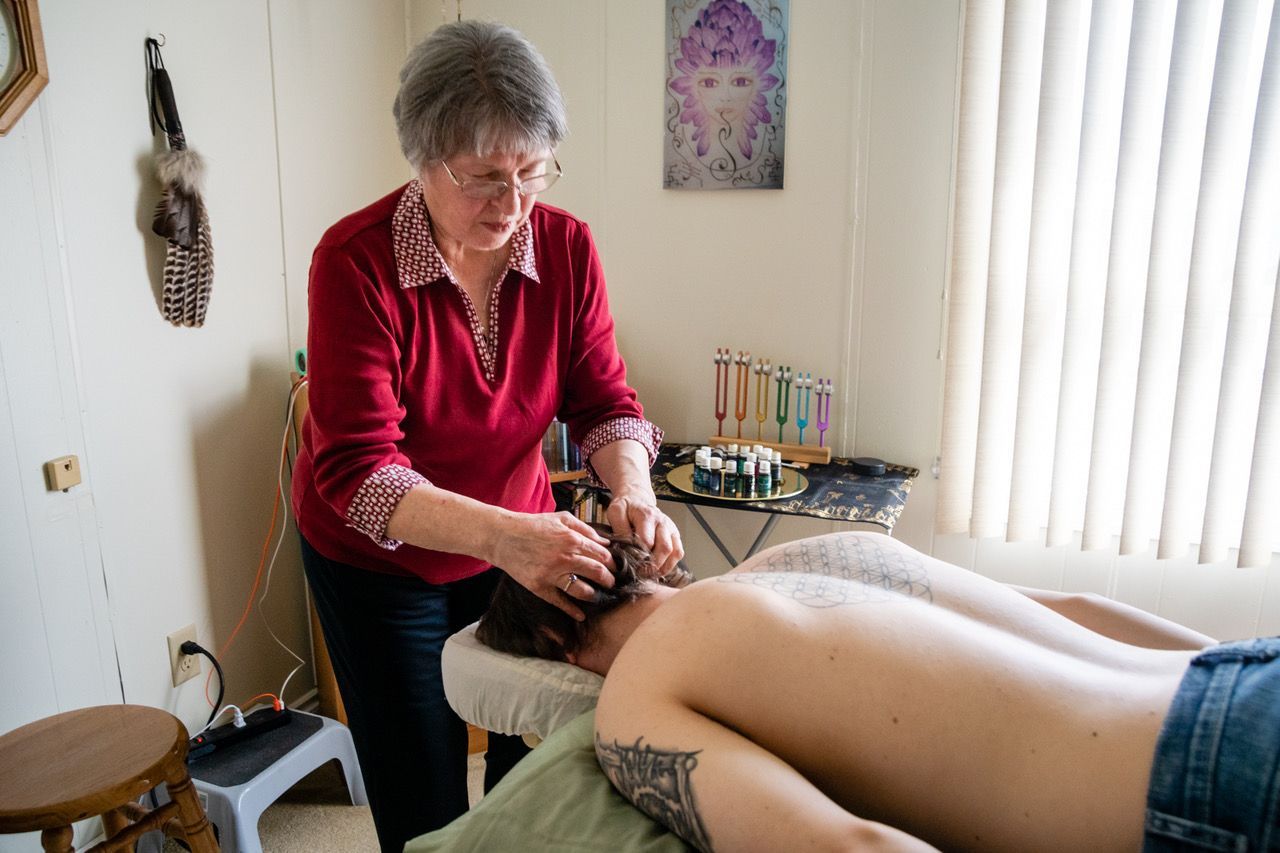 A woman is giving a massage to a woman laying on a table.