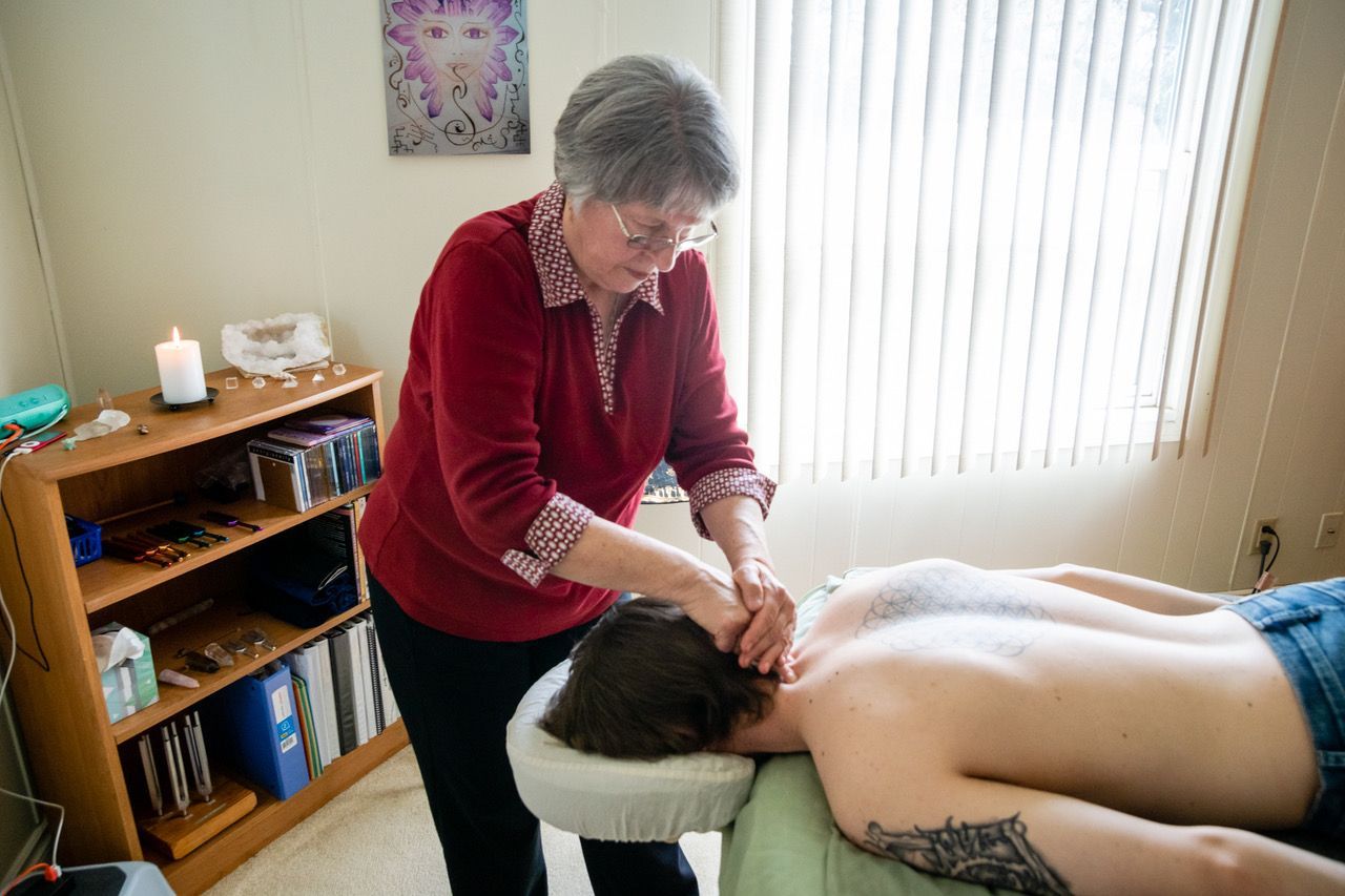 A woman is giving a man a massage on a table.