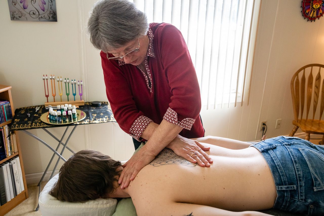A woman is giving a massage to a man in a living room.