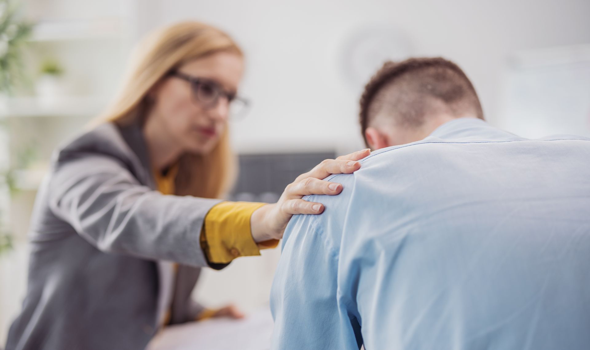 A woman is putting her hand on a man 's shoulder.