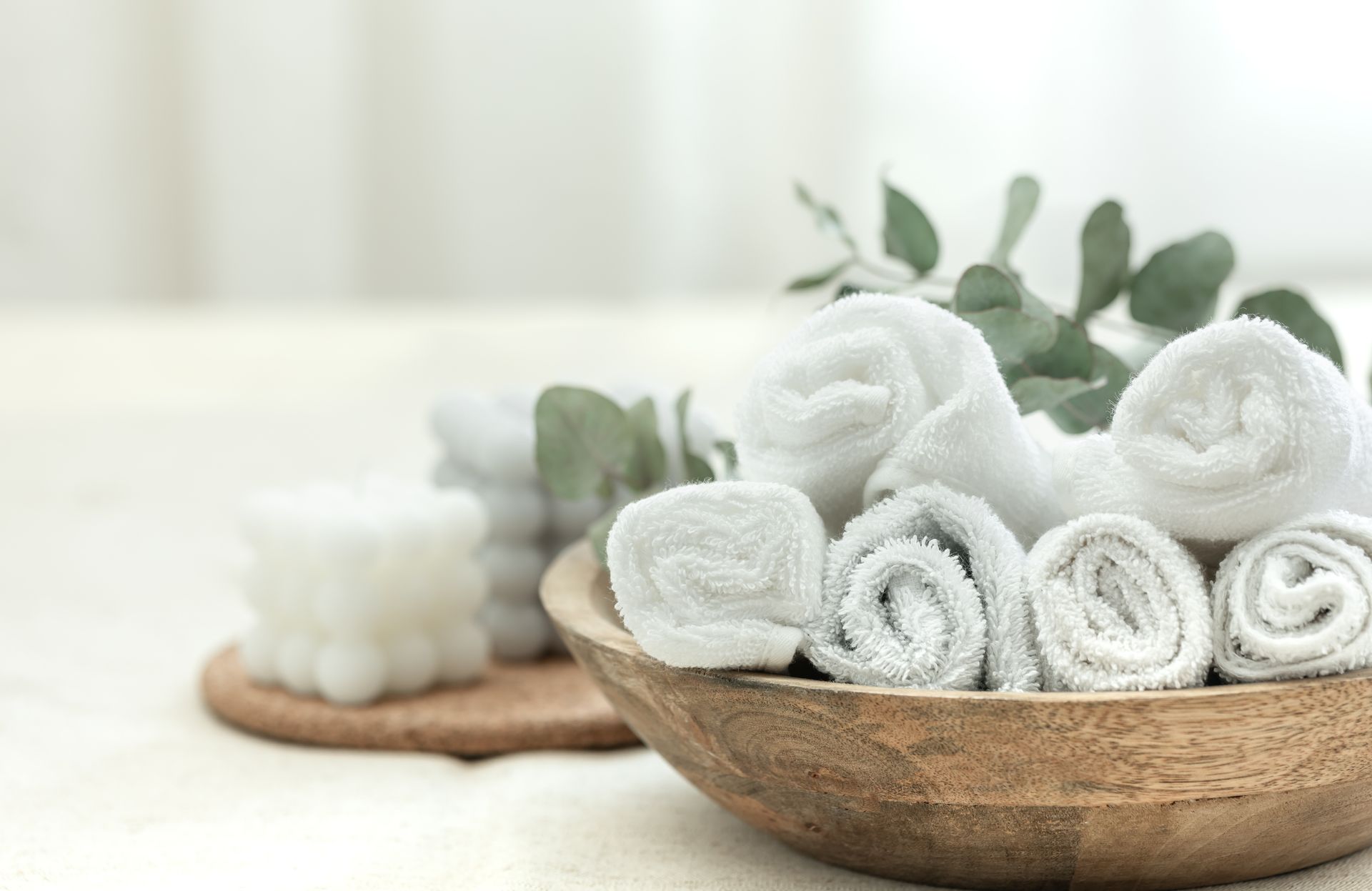 spa composition with white towels in a wooden bowl