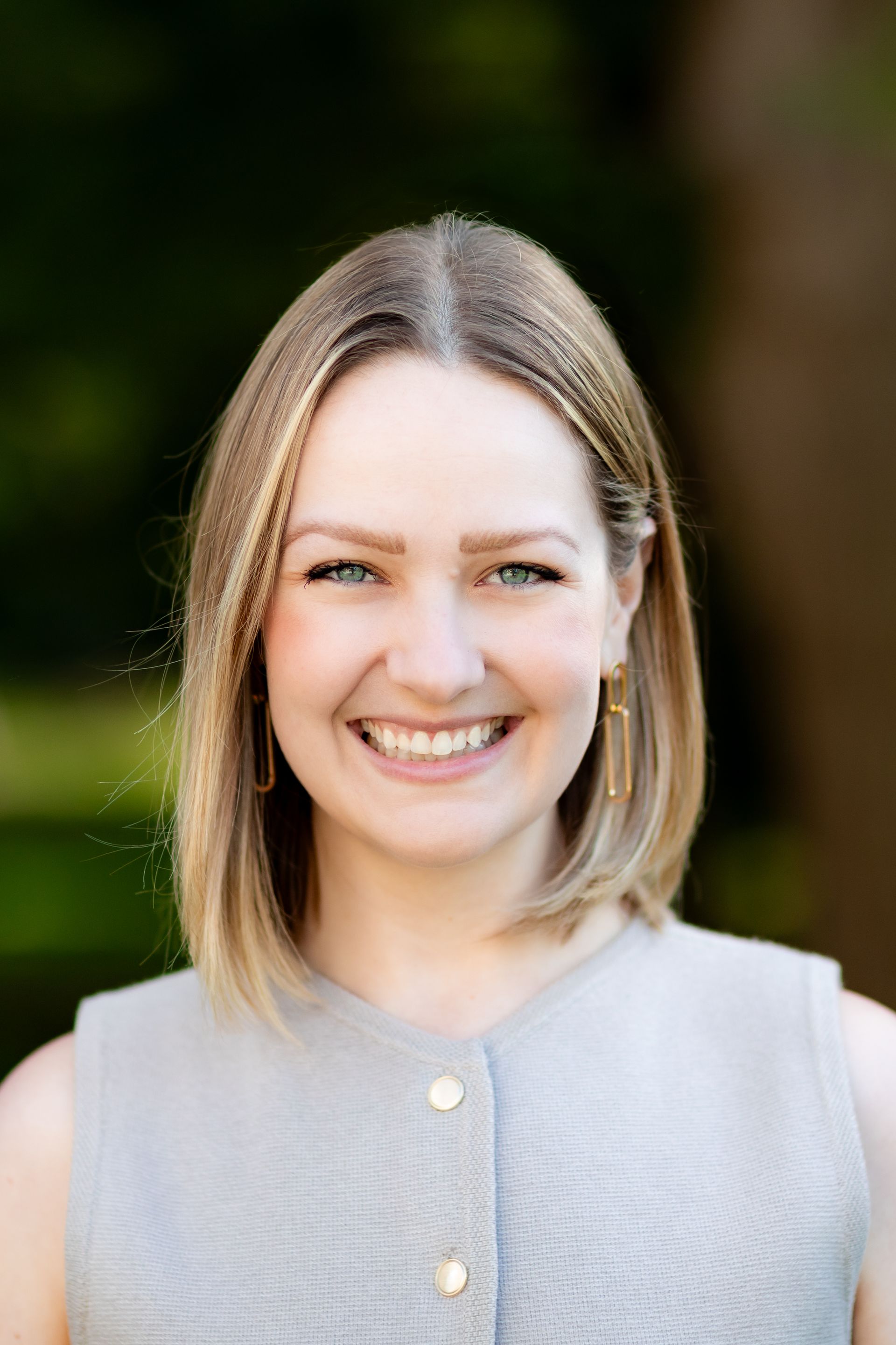 A woman in a black shirt is smiling for the camera.