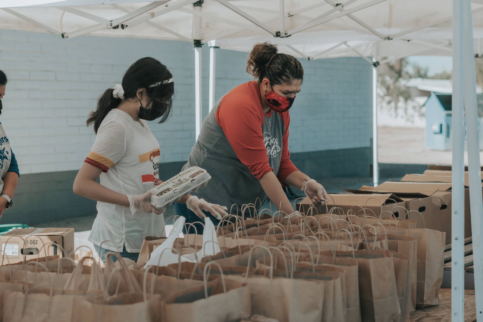 two women packing up bags of groceries to give away