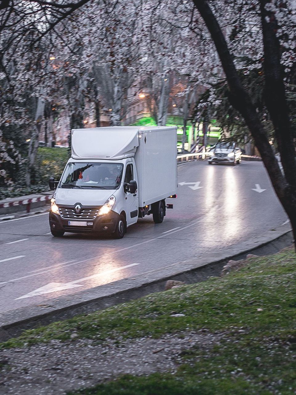 a white renault van is driving down a street