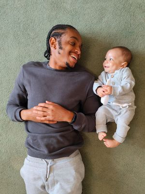 a man laying on the floor holding a baby