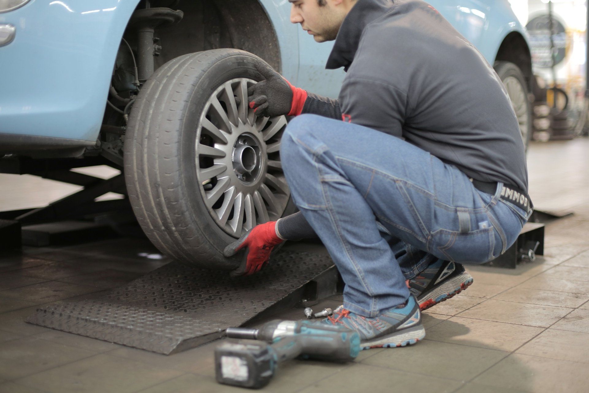 a man is working on a tire with a tool that says ' makita ' on it