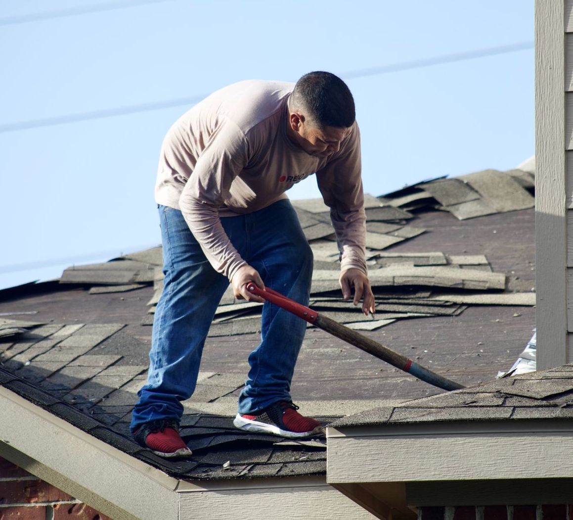 a man standing on a roof with a reebok shirt on