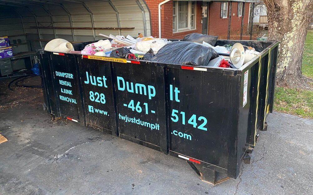 A dumpster filled with trash is sitting in front of a house.