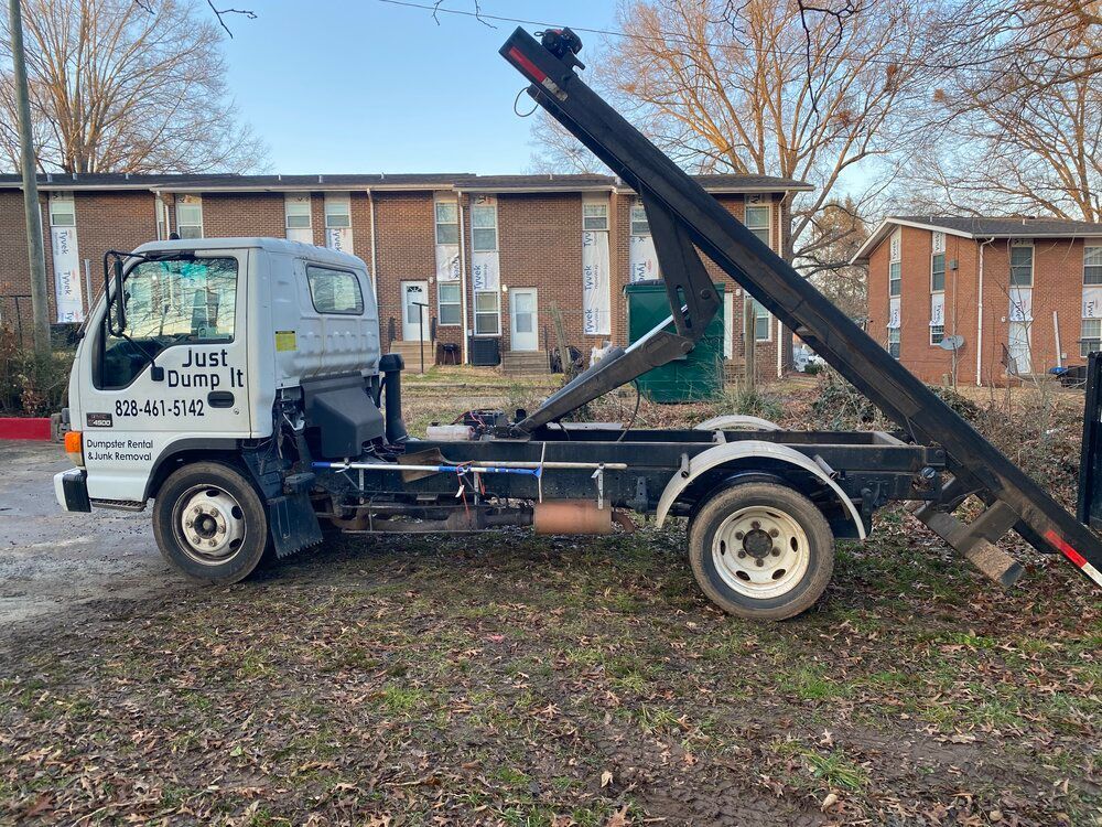 A dump truck is parked in front of a brick building.