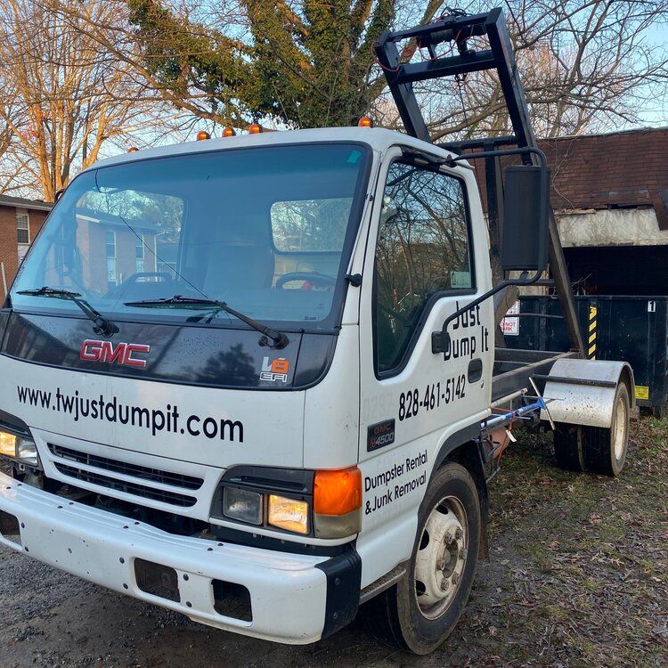 A white gmc dump truck is parked in front of a house.