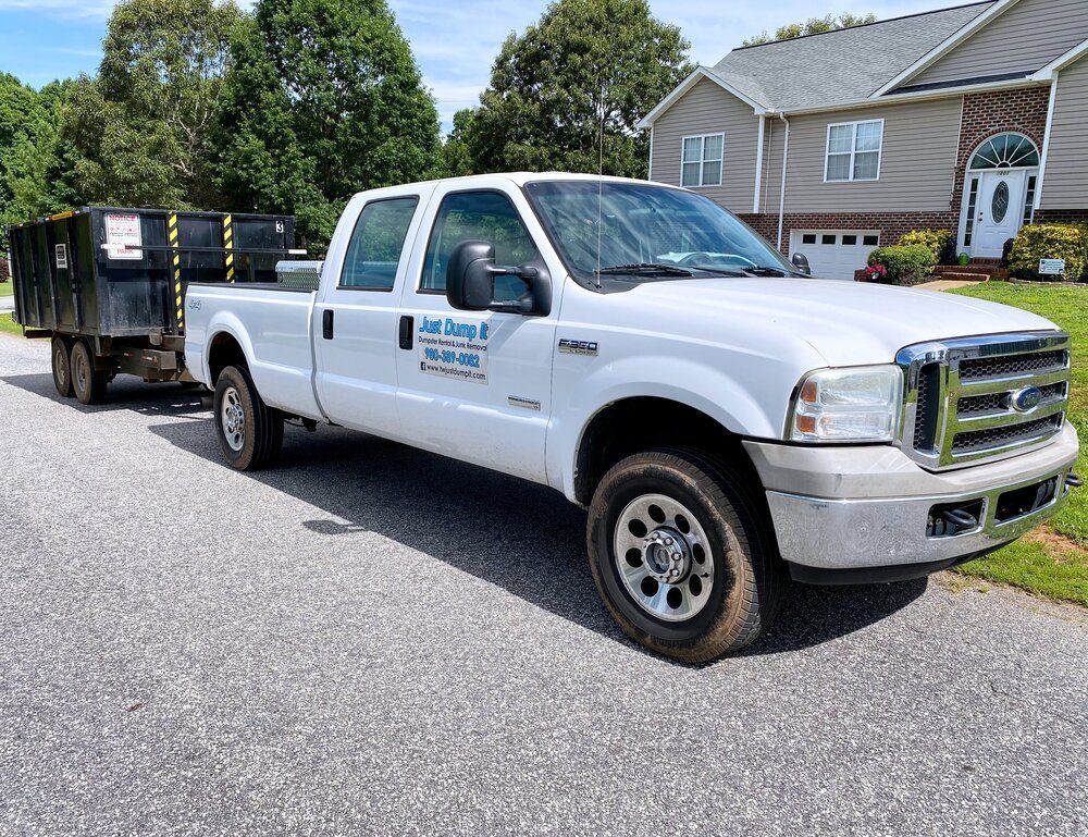 A white truck is parked on the side of the road next to a house.
