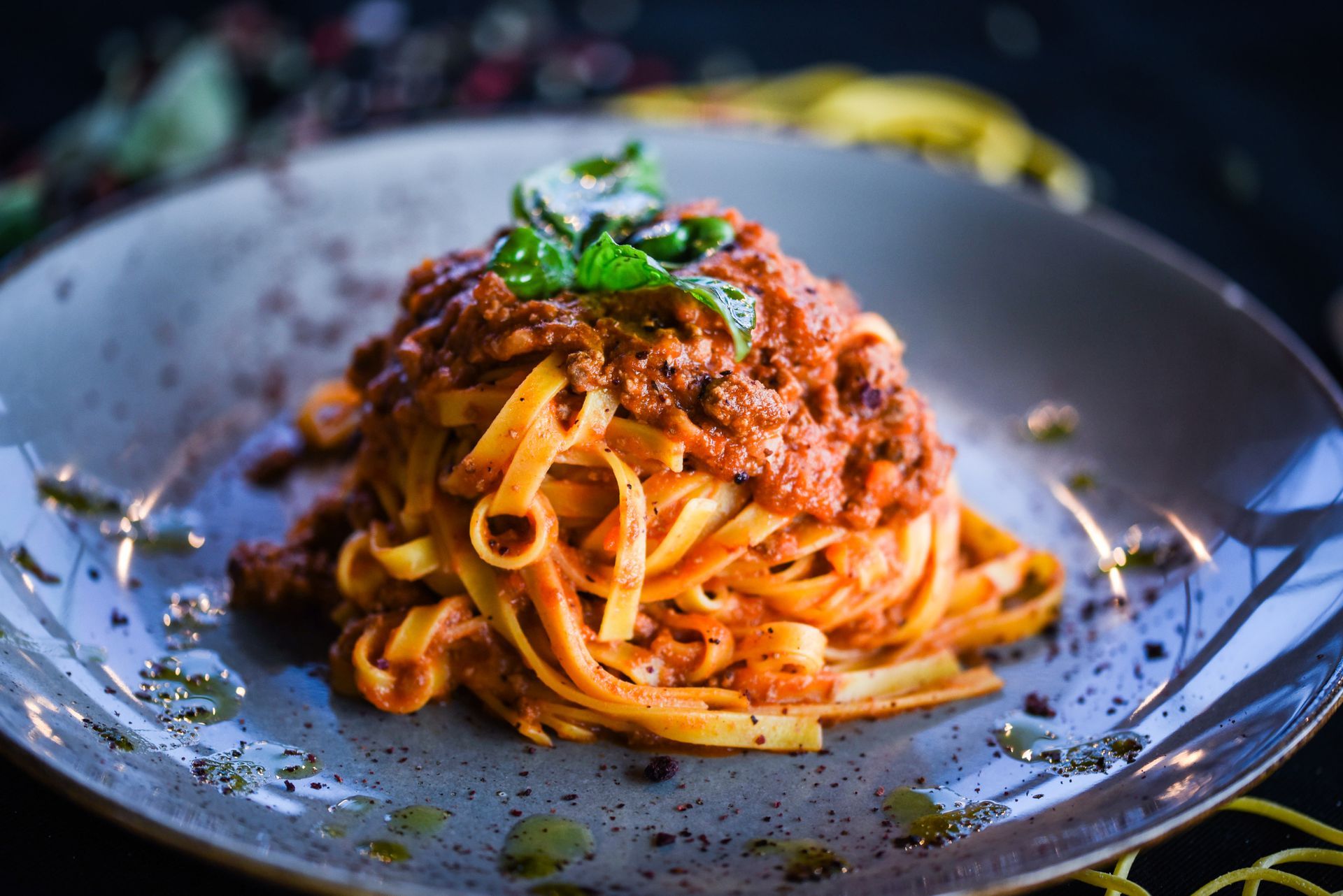 A close up of a plate of pasta with sauce on a table.