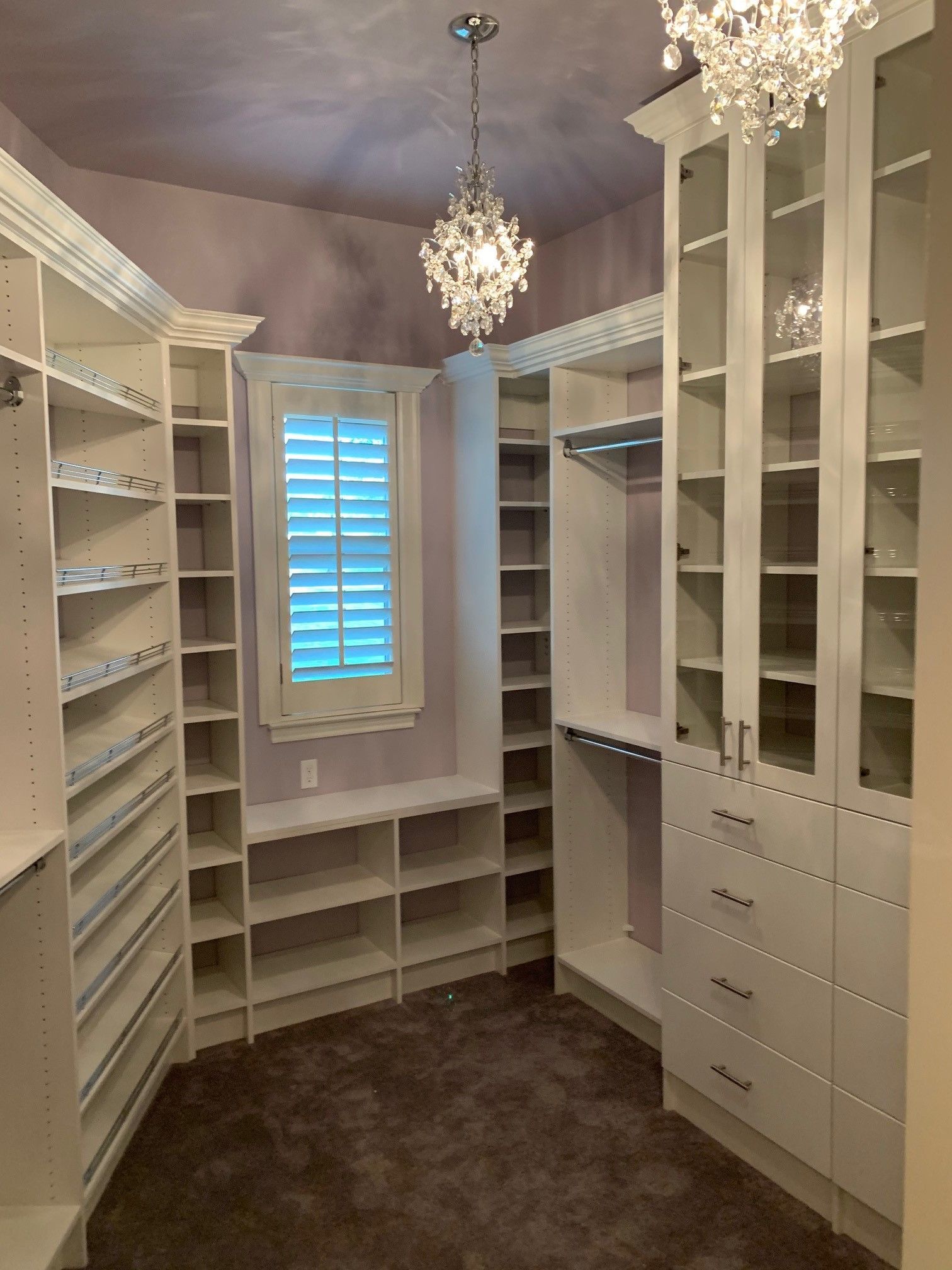 a walk in closet with lots of shelves and drawers
