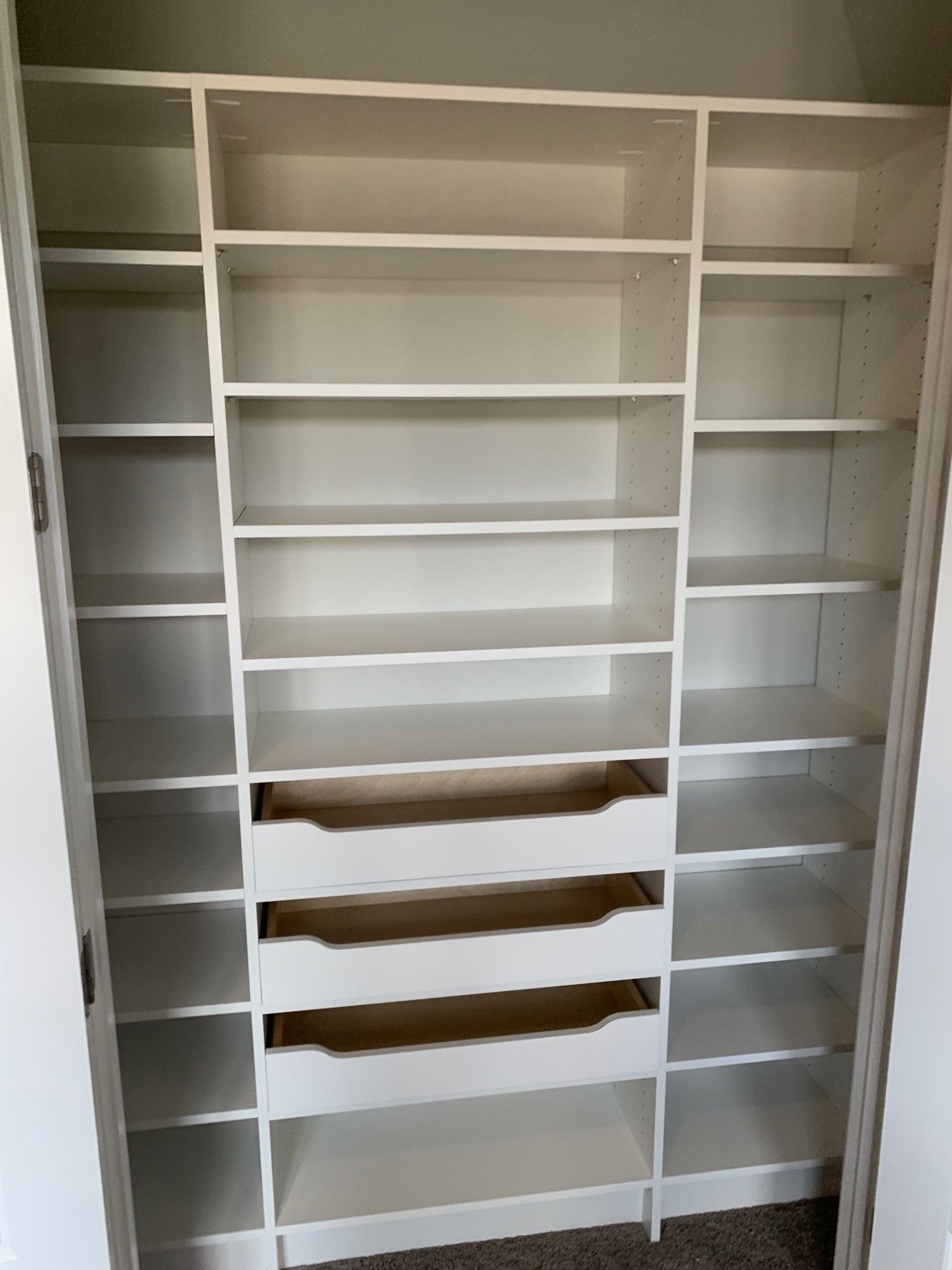 a custom pantry system filled with lots of shelves and drawers