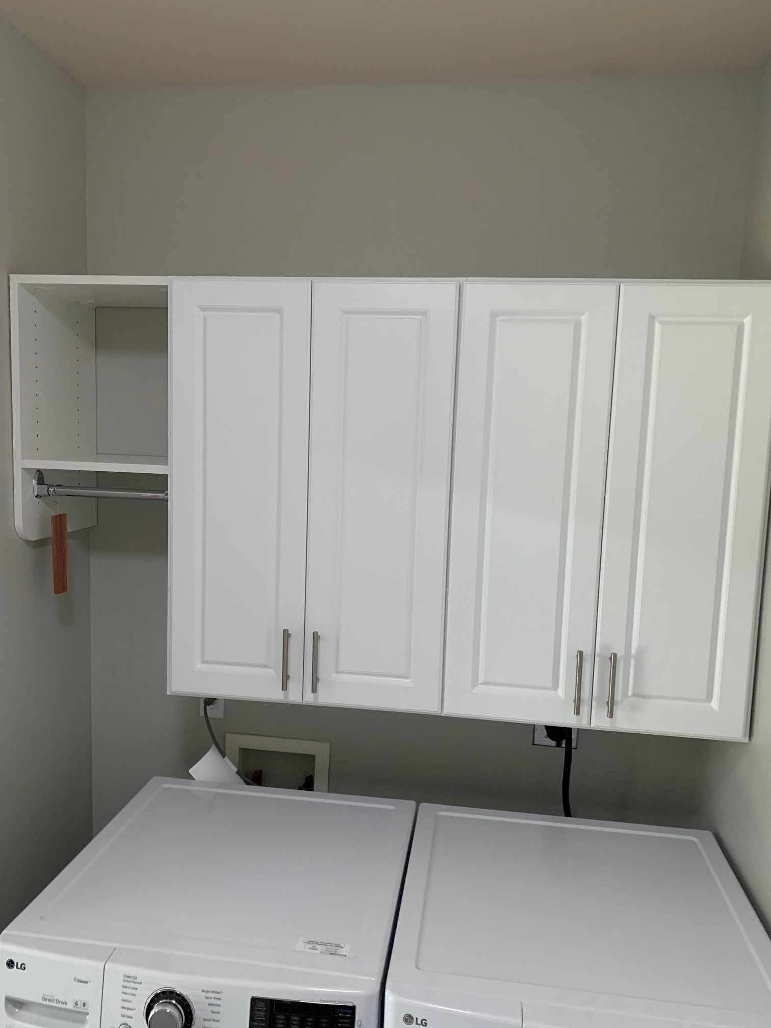 a laundry room with white cabinets and a washer and dryer