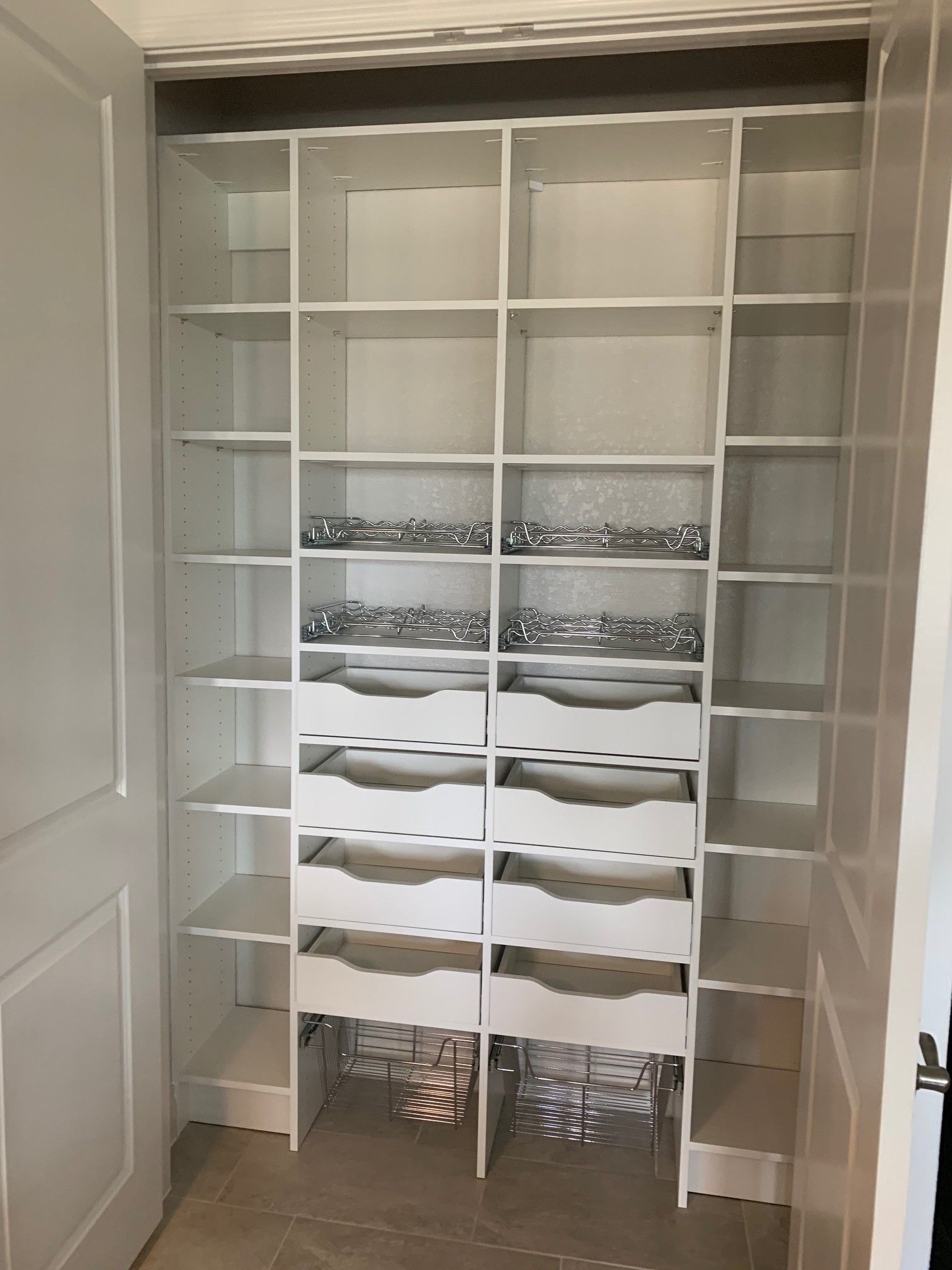 a pantry with lots of shelves and drawers