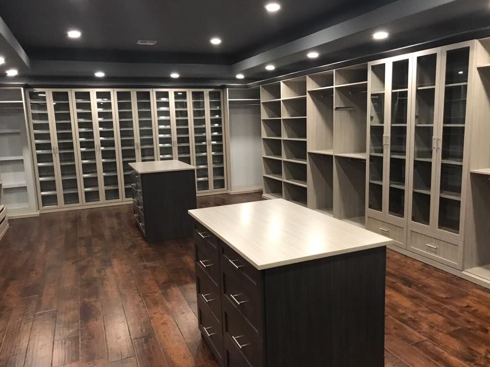 a large walk in closet with lots of shelves and drawers .