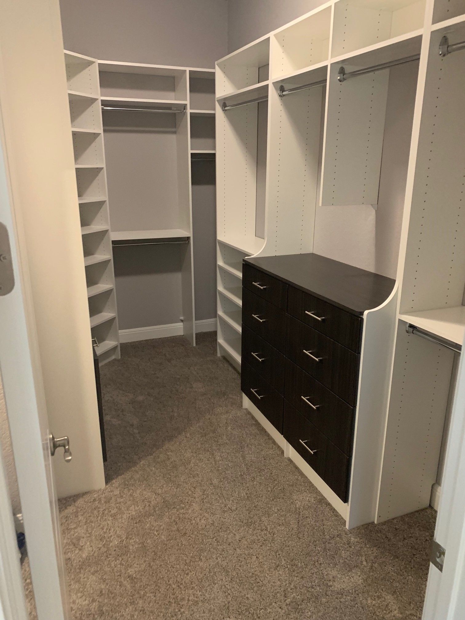 a walk in closet system with of shelves and drawers .