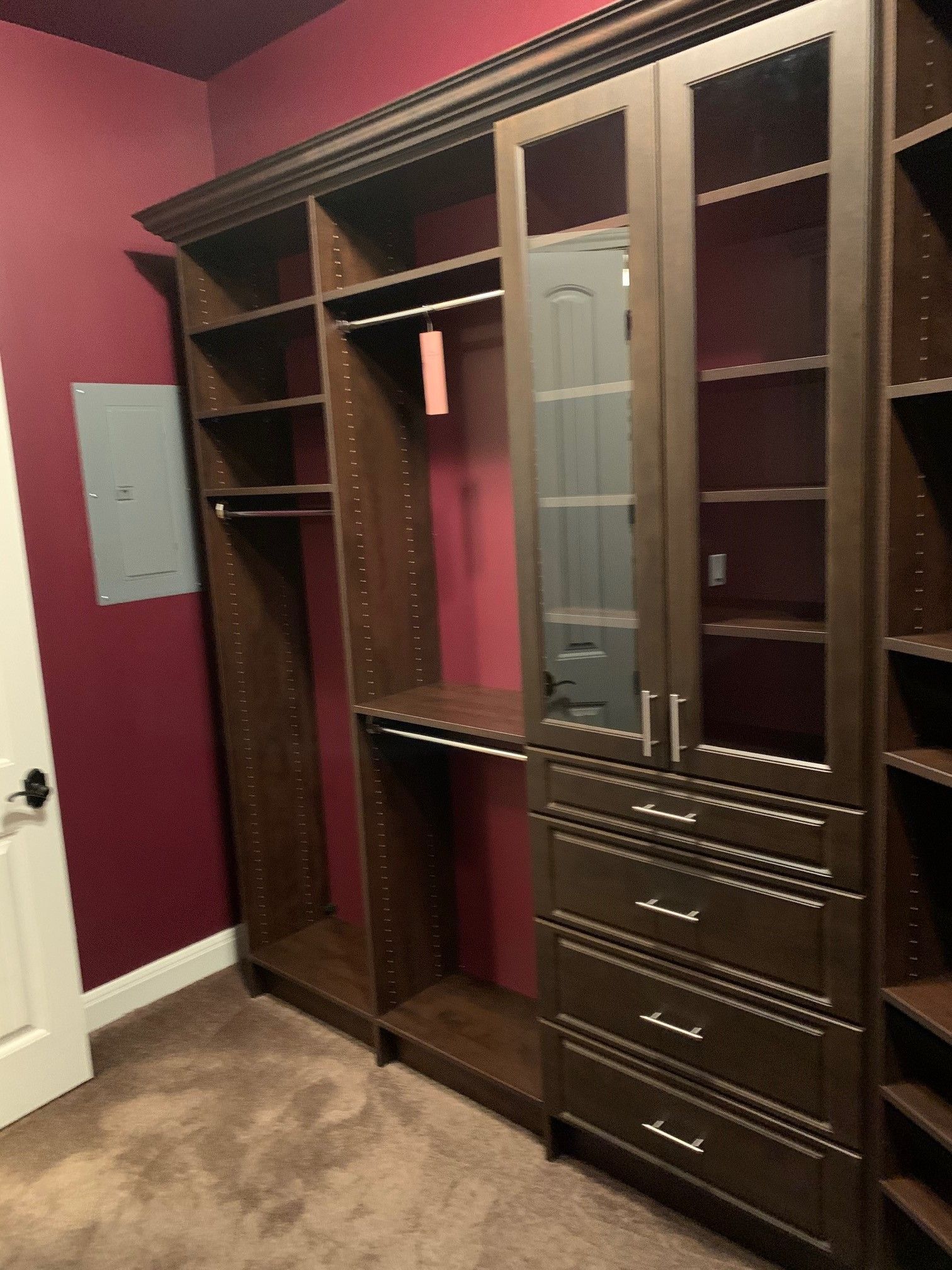 a dark wood closet system with lots of shelves and drawers