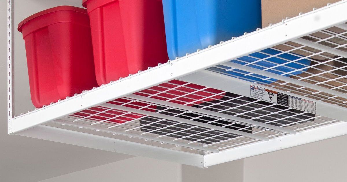 A shelf with red and blue bins on it in a garage.