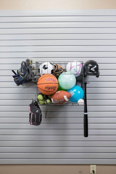 a bunch of sports equipment and balls are in an accessory rack on slatwall .