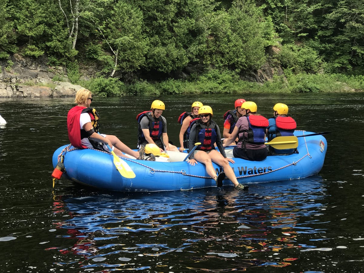 People sitting on rafting boat while steady