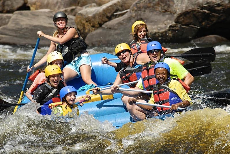 Group of people paddling while almost sink to the river