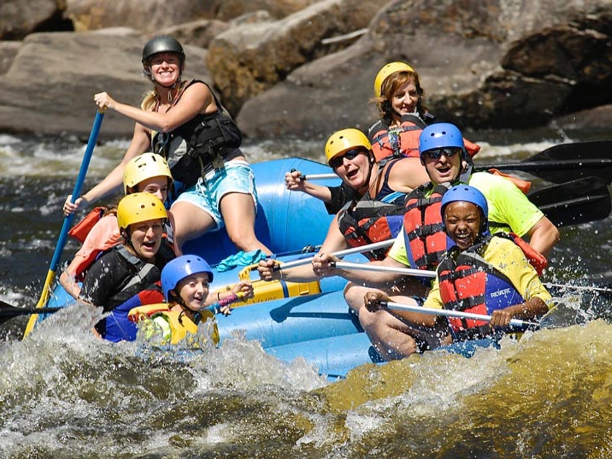 Group of people using blue rafting boat