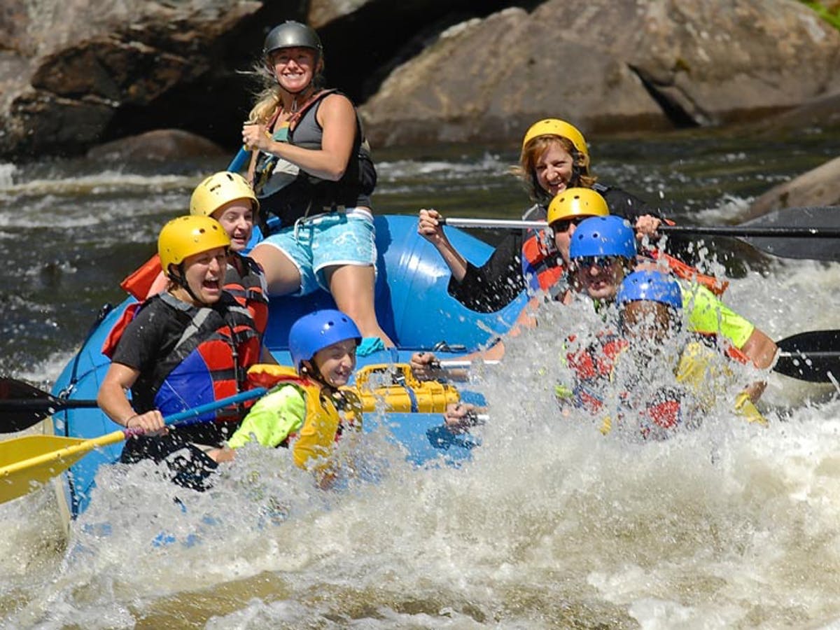 Group of people happy while the water is splashing to their boat
