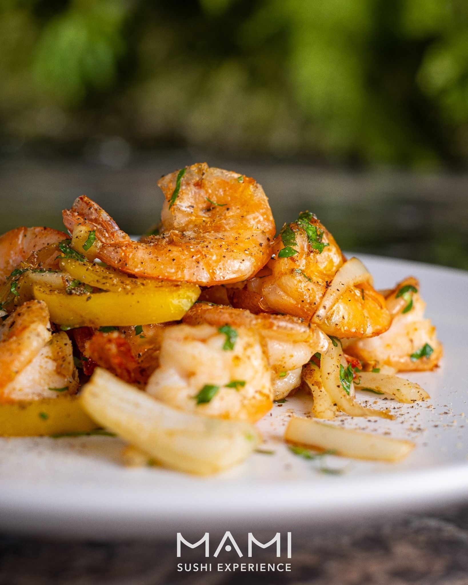 Gamberi cotti con spicchi di limone, guarnito con erbe aromatiche su un piatto bianco.