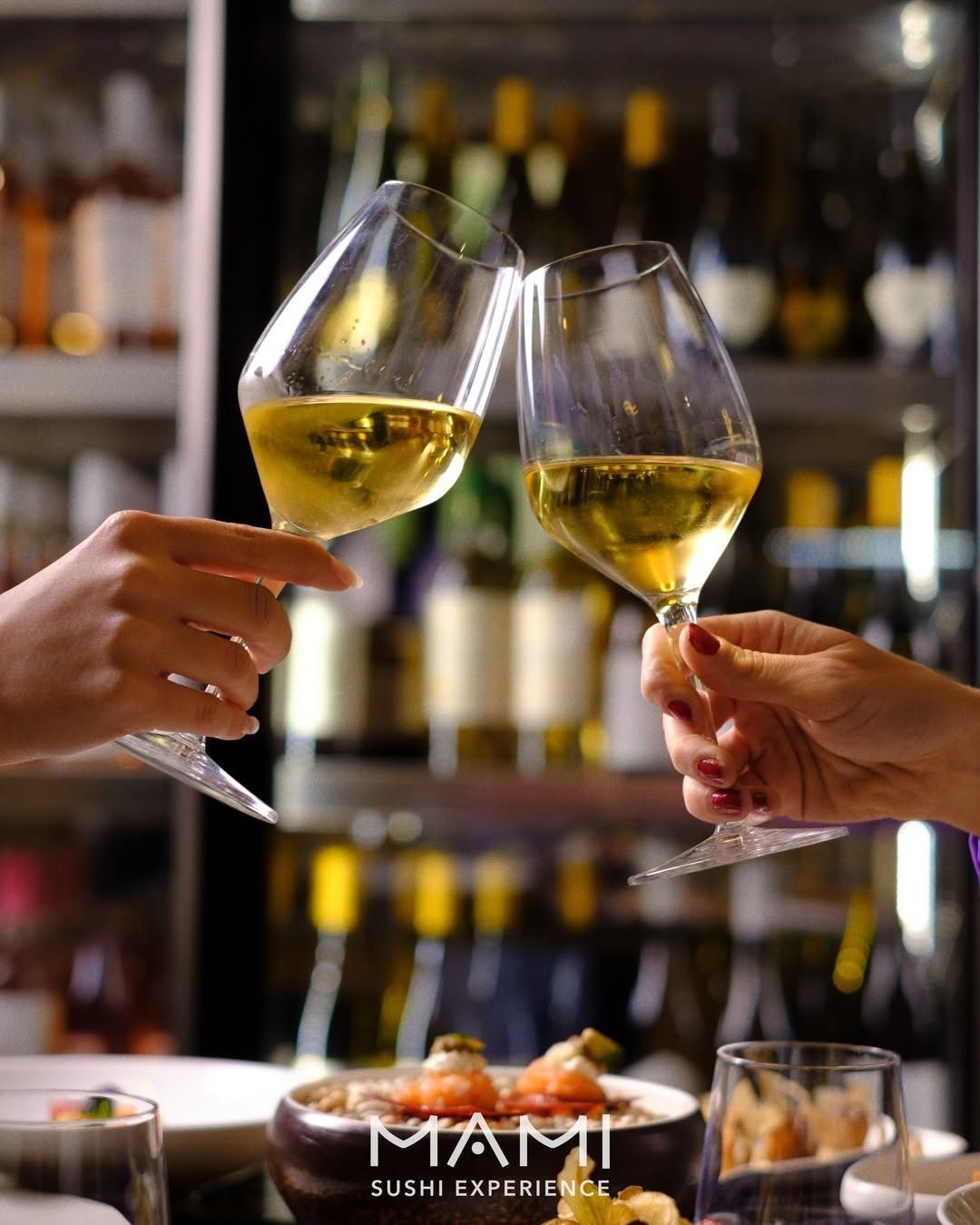 Due mani fanno tintinnare i bicchieri di vino, brindando