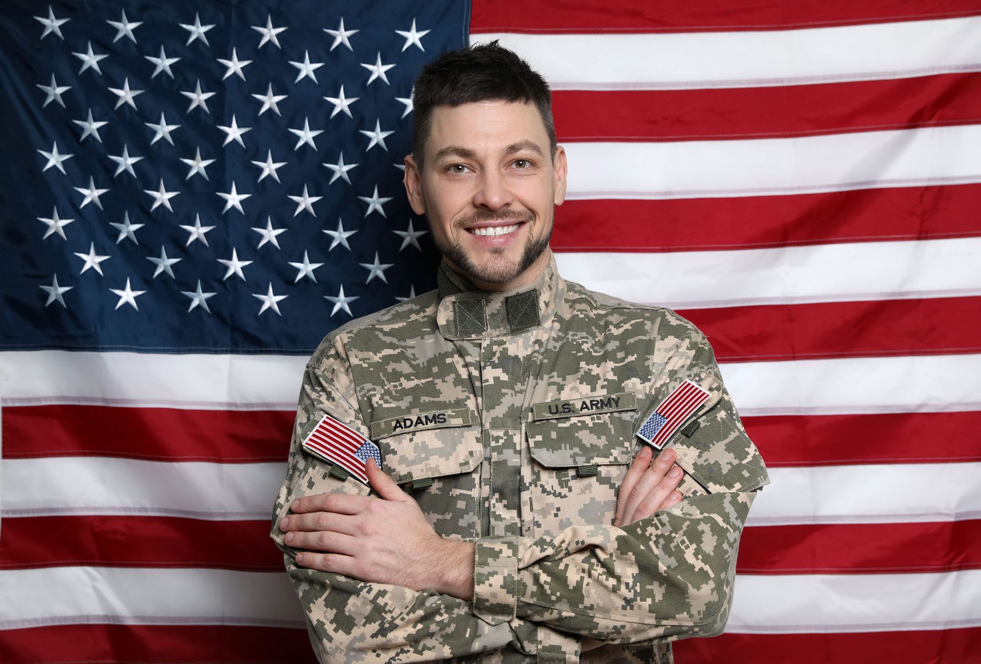 A smiling family of three posing together on a couch in a sunlit room.