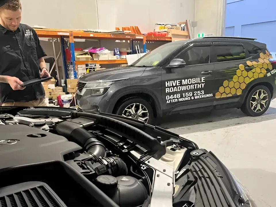 A Man is Working on the Engine of a Car in a Garage — Hive Mobile Roadworthy in Currumbin, QLD